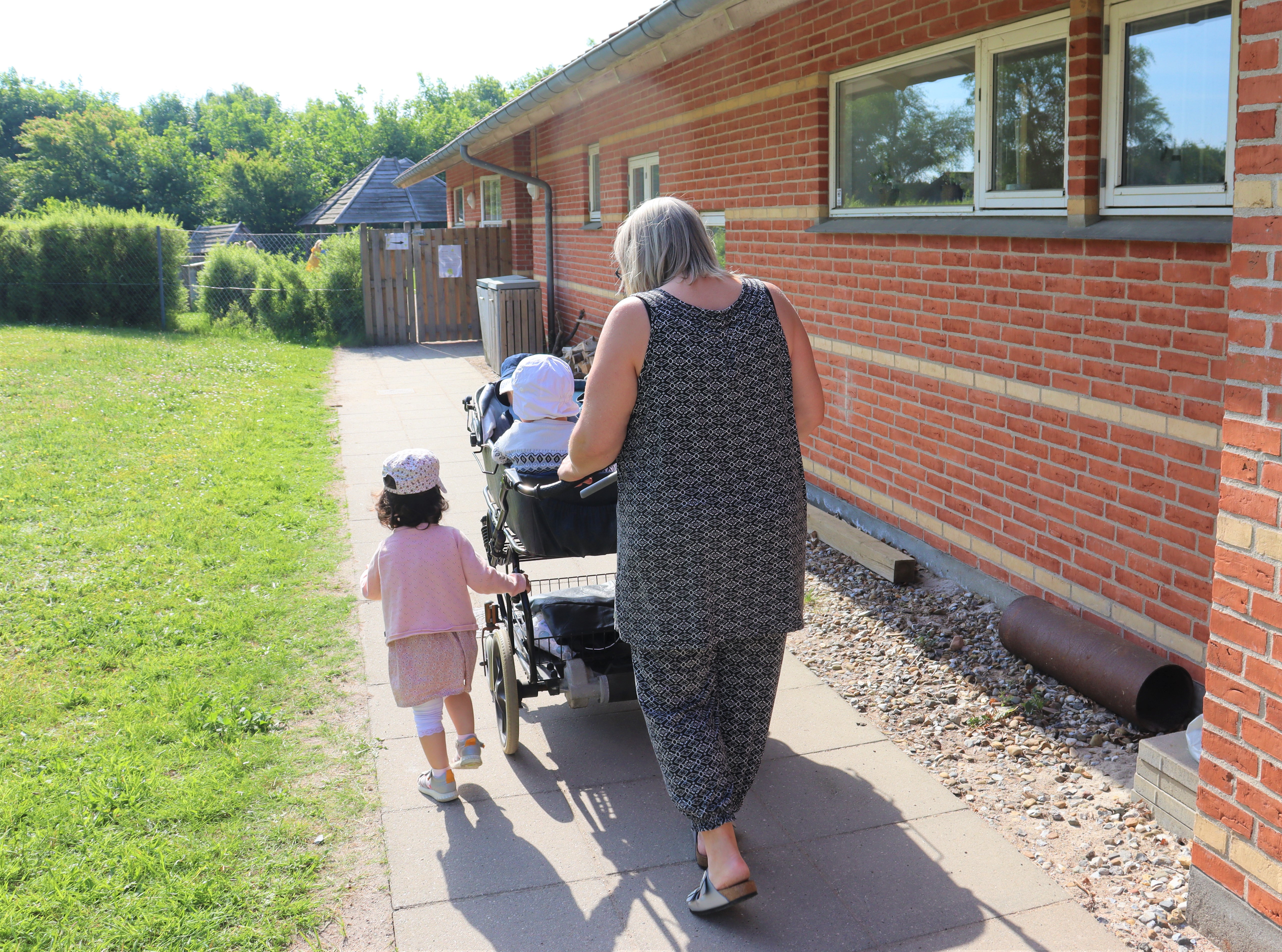 Dagplejer går tur med børnene i barnevognen